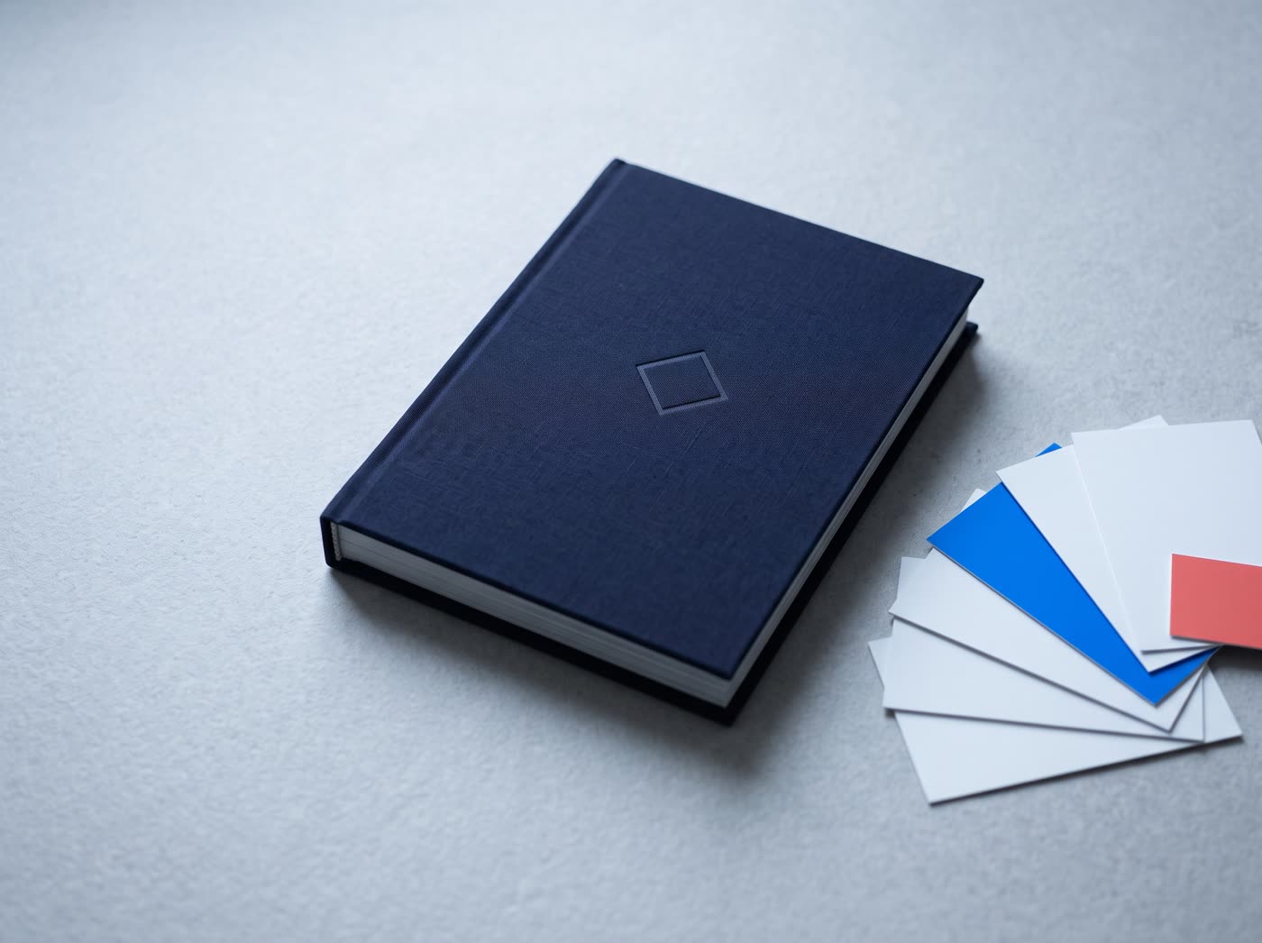 The Whitehart brand guide, closed, beside colour swatch cards
